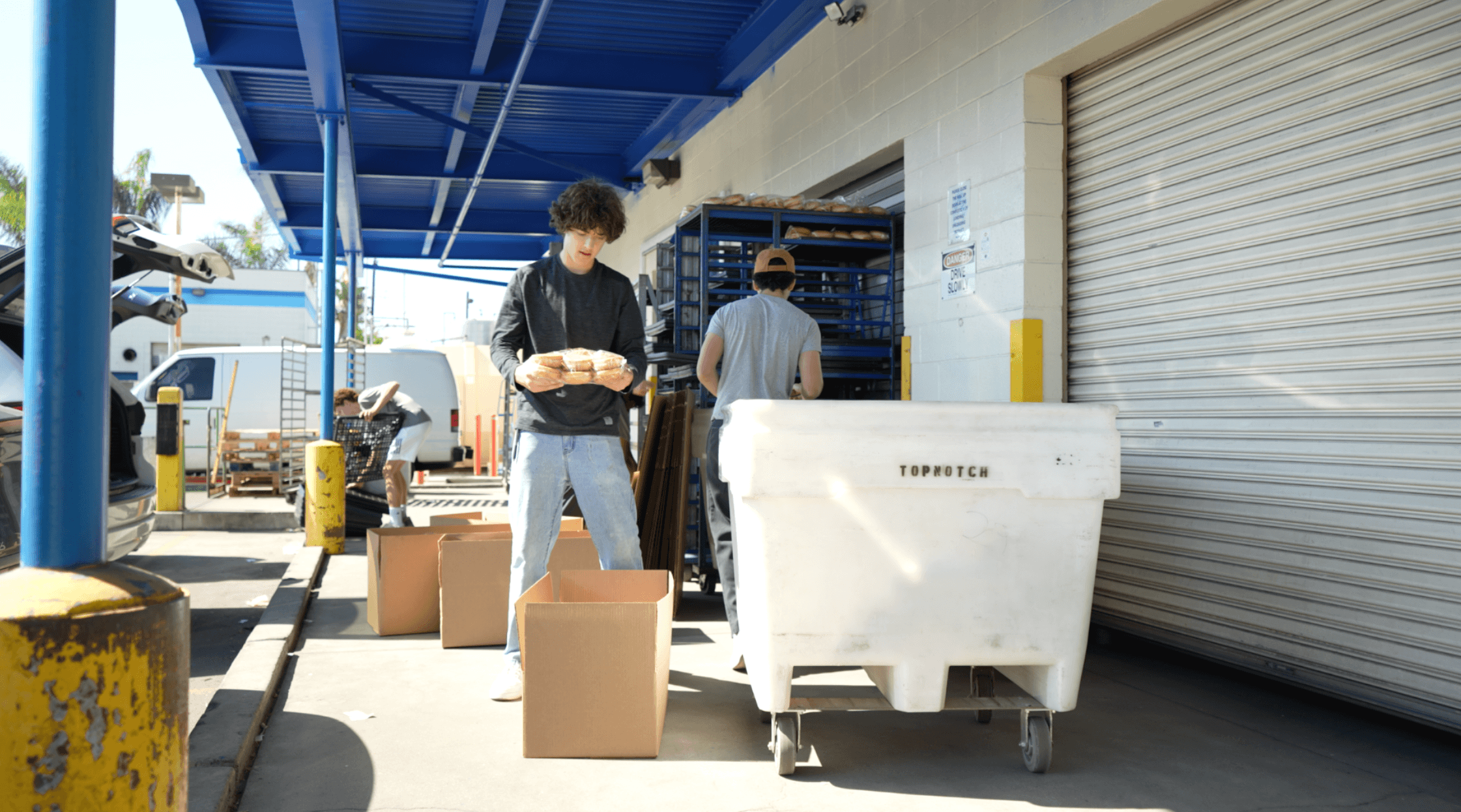 KneadLA volunteer loading bread at bakery